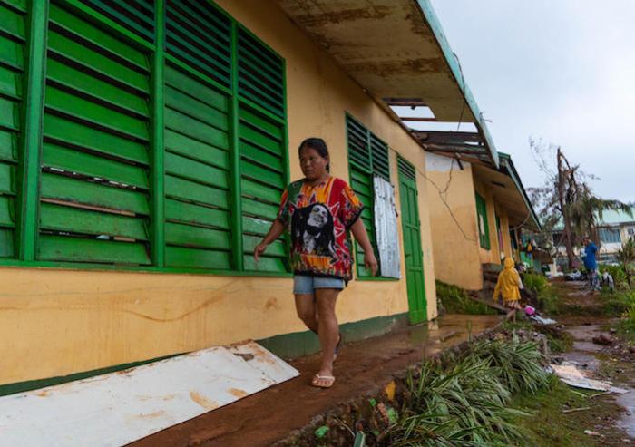 Nelly Cariño walks to the classroom where most members of her family have evacuated. More than a week after Typhoon Odette wreaked havoc on Dinagat Island, the family still can’t go home. They don’t have enough resources to rebuild what they have lost.