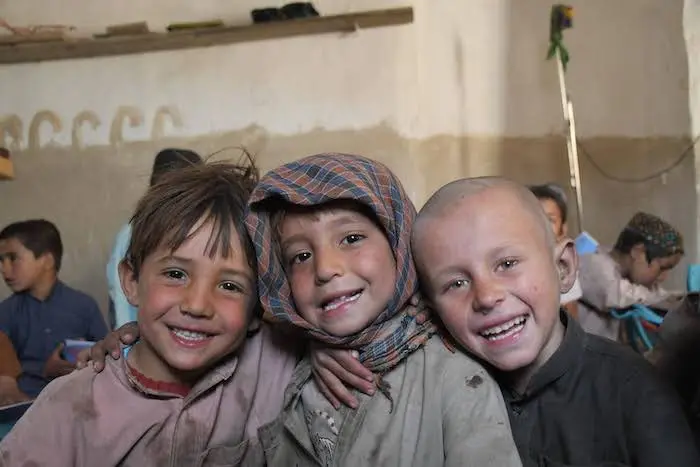 Three students at a UNICEF-supported community-based education center in Kandahar city, Afghanistan. Three students at a UNICEF-supported community-based education center in Kandahar city, Afghanistan.