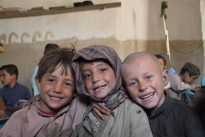 Three students at a UNICEF-supported community-based education center in Kandahar city, Afghanistan.