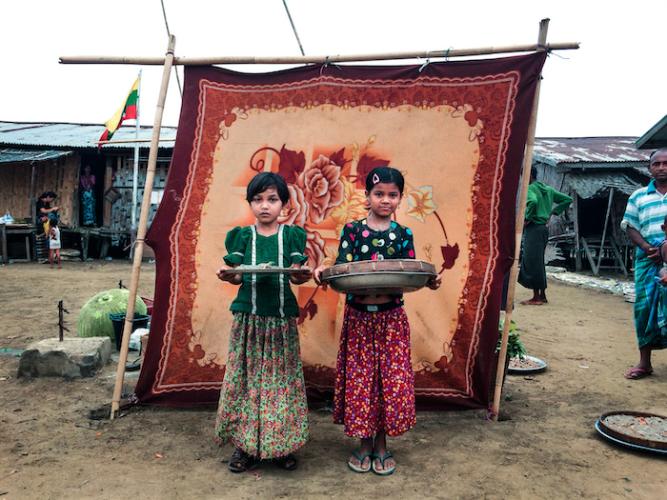 La La, 10, (left) and Noor Bi, 8, sell fish at the market in the Sin Tet Maw camp for families displaced by violence in Rakhine State, Myanmar.