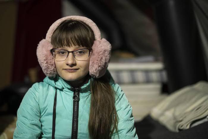 12-year-old Daria rests in a tent provided by a UNICEF local partner organization as she waits with her family for the right moment to continue their journey to France.