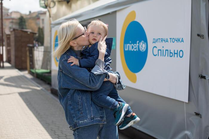 On April 27, 2022, in Ukraine, 18-month-old Sashko is held and kissed by his mother, Kateryna, 27, in front of UNICEF's "Spilno" Child Spot in Ternopil.