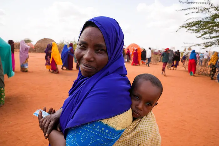 A mother carries her 2-year-old son through the Kaharey camp in Dollow, Somalia, where families displaced by severe drought can access UNICEF support including clean safe drinking water. A mother carries her 2-year-old son through the Kaharey camp in Dollow, Somalia, where families displaced by severe drought can access UNICEF support including clean safe drinking water.