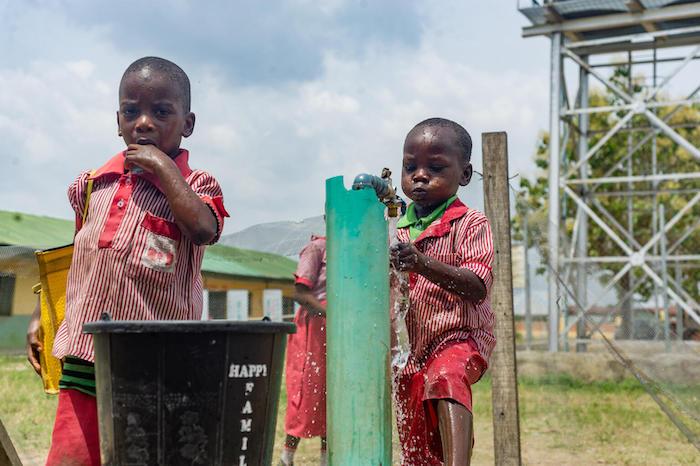 Two boys washing their hands in a primary school in Nigeria.