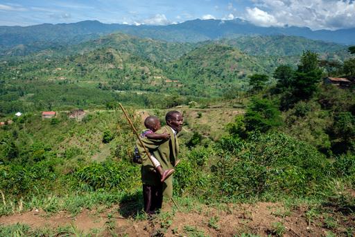 Jonathan Mbusa, 70, carries his 3-year-old granddaughter, Asinet, to a field in western Uganda, where they grow vegetables together. Asinet has been living with her grandparents since she was born. Jonathan creates a healthy, nurturing environment.