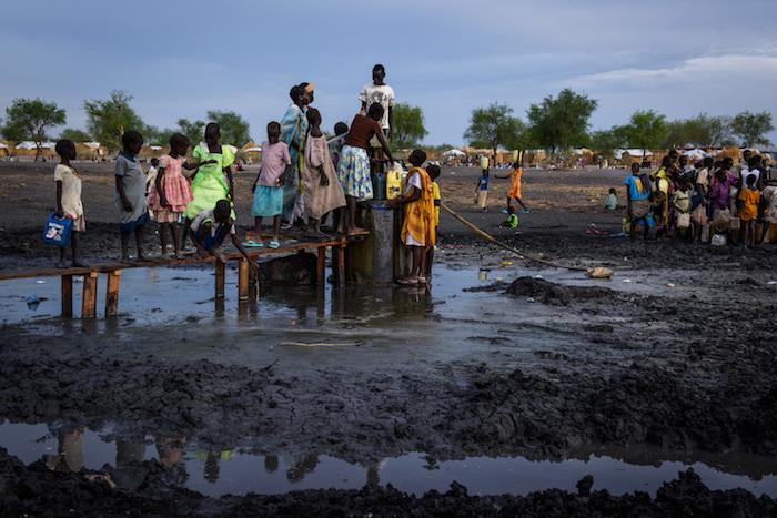 Drawing water at a borehole in the river bed running through the village of Aburoc, South Sudan, where thousands of people, displaced by fighting near their homes, live in the open. © UNICEF/UN065988/Hatcher-Moore