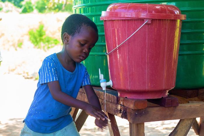 In Nedi Camp, Malawi, a 5-year-old boy washes his hands, an important cholera prevention measure. 
