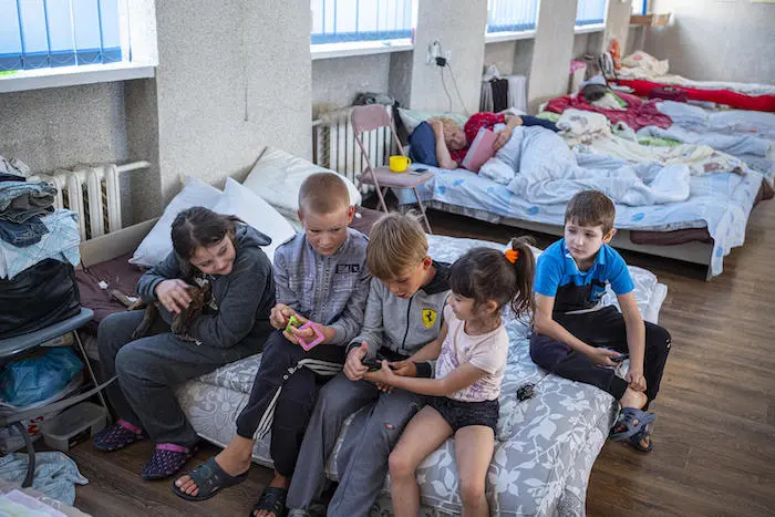 Children sit on a bed at Tvoya Opora, a community-built and -funded shelter for people displaced by the war Children sit on a bed at Tvoya Opora, a community-built and -funded shelter for people displaced by the war
