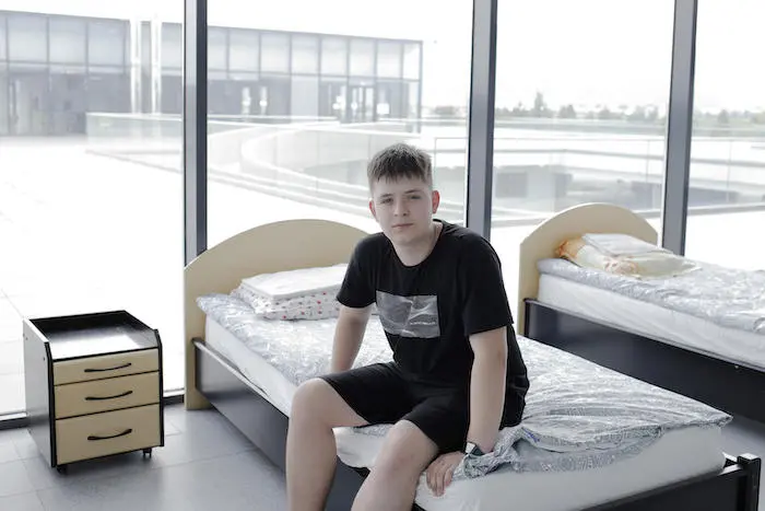 Teenage boy sitting on bed in UNICEF-UNHCR Blue Dot hub in Brasov, Romania Teenage boy sitting on bed in UNICEF-UNHCR Blue Dot hub in Brasov, Romania