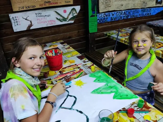 Two 10-year-old girls draw together at a Scouts camp in Poland, August 2022. Two 10-year-old girls draw together at a Scouts camp in Poland, August 2022.