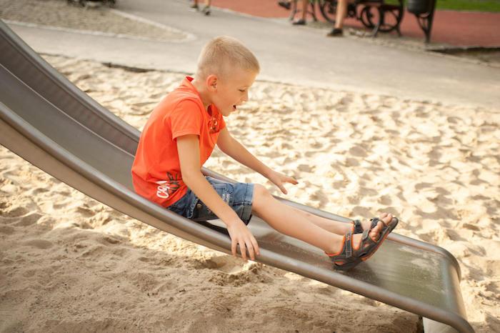 A refugee child from Ukraine slides down in a playground in Krakow, Poland