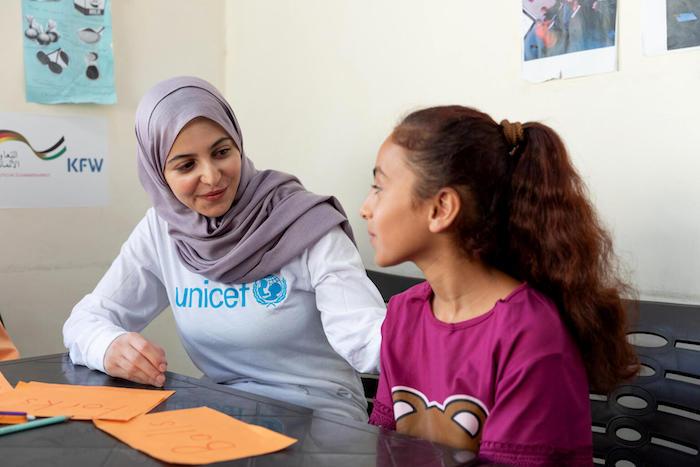 UNICEF Goodwill Ambassador Muzoon Almellehan sits with 11-year-old Raghad in an English learning support class at a UNICEF-supported Makani center in East Amman, Jordan.