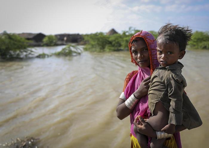 A mother and her 16-month-old child, Hera, beside floodwaters near their village in Umerkot district, Sindh Province, Pakistan.