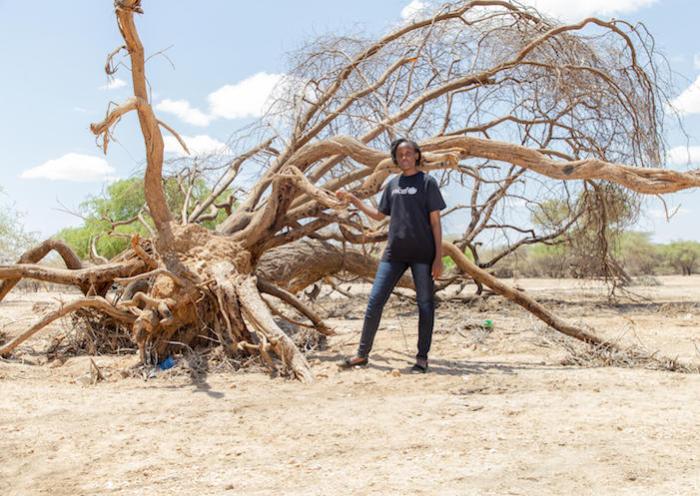UNICEF Goodwill Ambassador Vanessa Nakate stands beside a dead tree and a dry riverbed in Sopel, Turkana County, Kenya on Sept. 9, 2022.