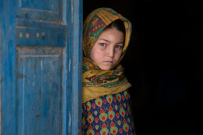 Nine-year-old Asna stands by the door at her home in Afghanistan. Nine-year-old Asna stands by the door at her home in Afghanistan.
