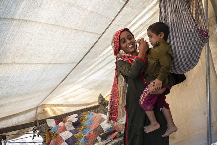 In Jacobabad, Sindh province, one of the worst flood affected areas in Pakistan, 15-year-old Sugra holds her brother, Fayaz, in the tent they are staying in next to their destroyed home.