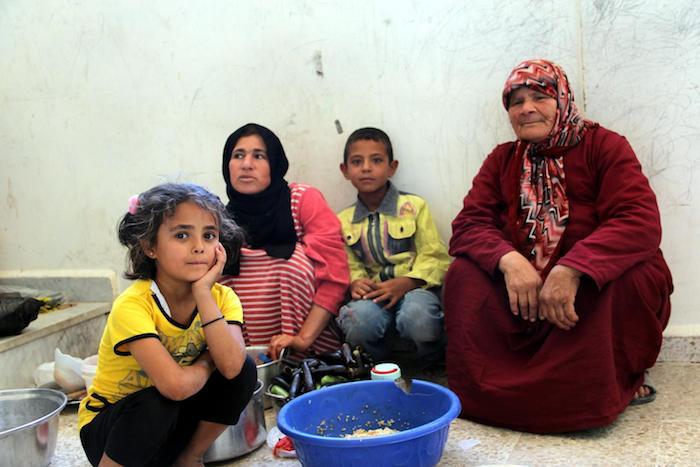 A family gathers during preparation of an evening meal during Ramadan in the rural town of Hassayia, near Homs, Syria, in 2013.
