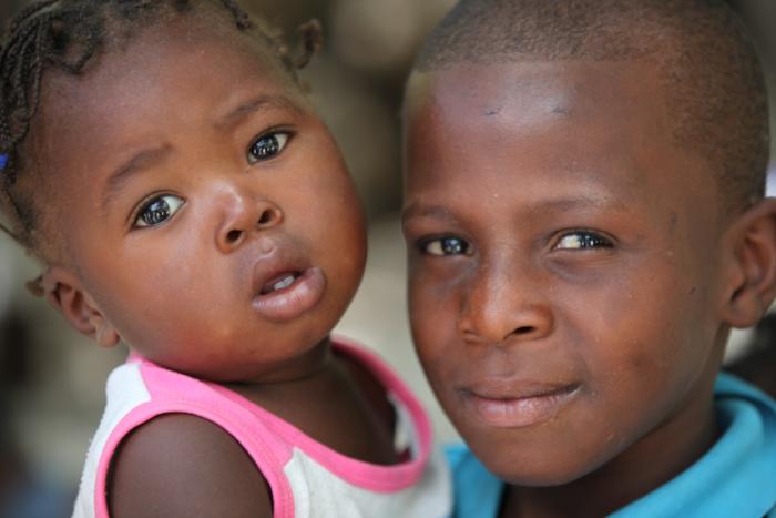 Two children at the UNICEF-supported mobile vaccination station set up outside a church by the side of the road in Haiti.