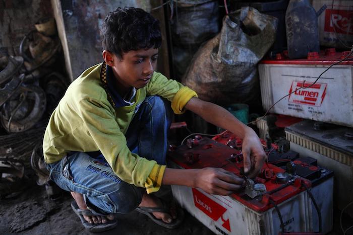 10-year-old Al Amin's job repairing batteries at a garage in Dhaka puts him at risk of lead exposure and its ill effects.