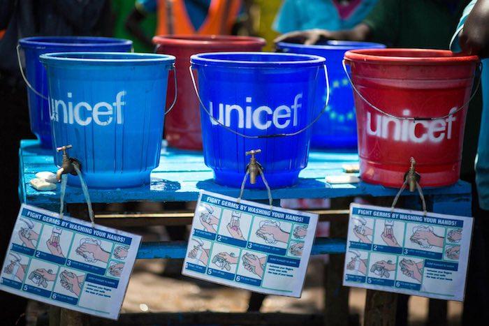 plastic buckets with taps sit on a table in Kule camp, where refugees from South Sudan have fled, 42 kilometres from Gambella town. An illustrated flyer hangs around each tap, demonstrating proper handwashing techniques that help prevent the spread of ger