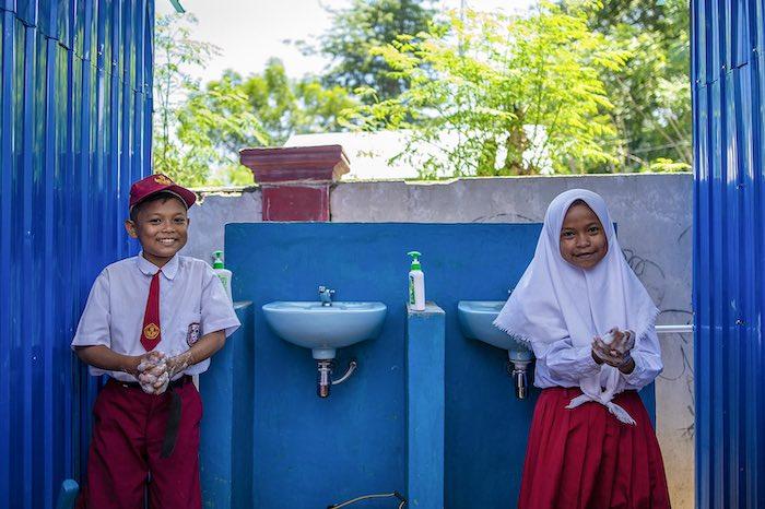 Biyan Saputra, 12 (left) and Sisil Agustin, 12 wash their hands at SDN 9 Sindue in Donggala, Central Sulawesi, Indonesia. Sindue SDN 9 school building was damaged by the earthquake that took place in Palu on 28 September, 2018. As part of the emergency 