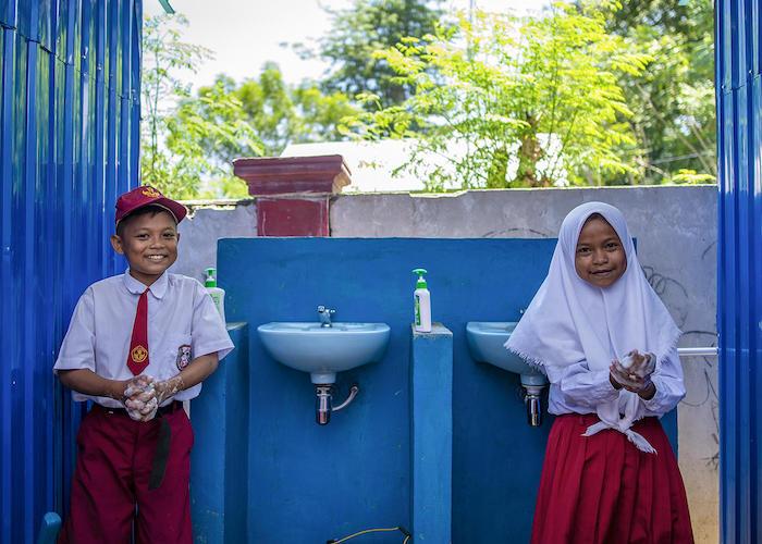On September 9, 2019, 12-year-olds Biyan (left) and Sisal wash their hands at a sink set up by UNICEF at their school in Donggala, Central Sulawesi, Indonesia. 