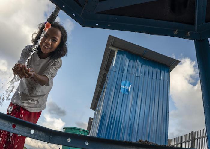 In Donggala, Central Sulawesi, Indonesia, a girl washes her hands near toilets built by UNICEF in temporary shelters for survivors of the September 2018 earthquake and tsunami. 