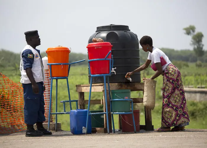 On September 16, 2019, a woman washes her hands in chlorinated water at a border crossing from the Democratic Republic of the Congo into Burundi. On September 16, 2019, a woman washes her hands in chlorinated water at a border crossing from the Democratic Republic of the Congo into Burundi.