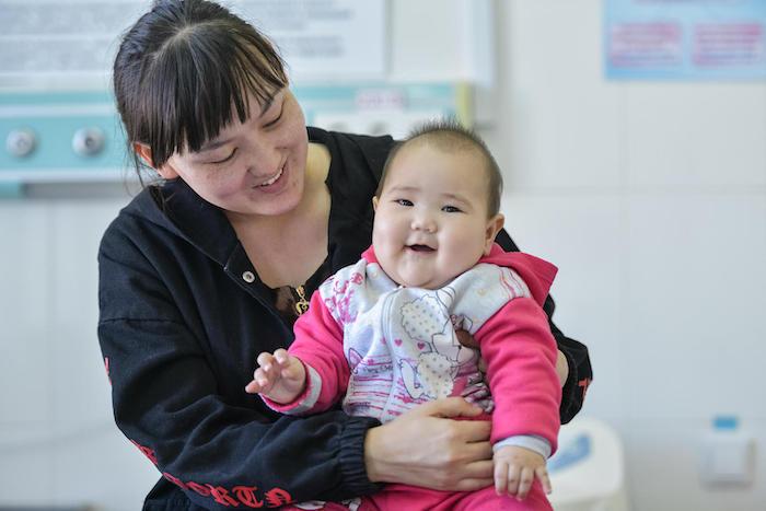 On March 13, 2019, 7-month-old Aisezim smiles on her mother's lap after being treated for pneumonia in the emergency room of a UNICEF-supported clinic in Turkestan, Kazakhstan. 