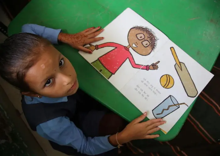 UNICEF is working with partners to improve learning outcomes for schools in India. Here, a student looks up from her book at Ranitaria School in Rainandgaon, Chattisgarh.