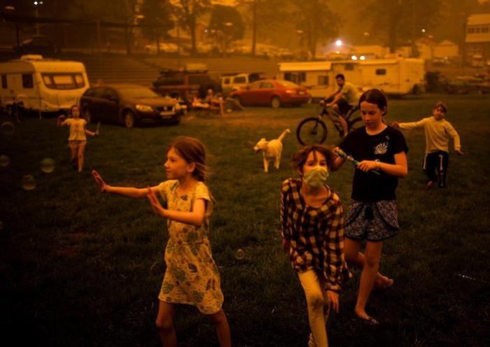 Children play at the showgrounds in the southern New South Wales town of Bega where they are camping after being evacuated from nearby sites affected by bushfires on December 31, 2019. 