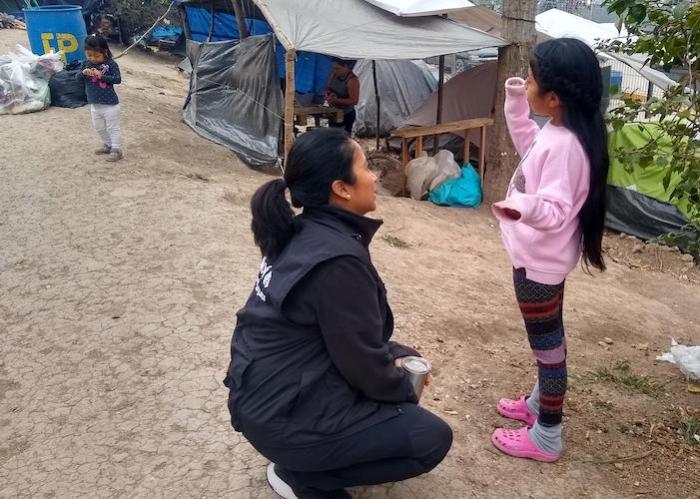 On January 29, 2020, UNICEF Mexico Deputy Representative Pressia Arifin-Cabo speaks with a child in an encampment in Matamoros in the northeastern state of Tamaulipas. 