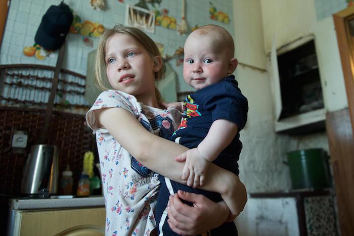 Impoverished families in Kazakhstan like 10-year-old Lyubov's, shown here holding her baby brother Daniil, are recipients of a UNICEF-supported cash assistance program.