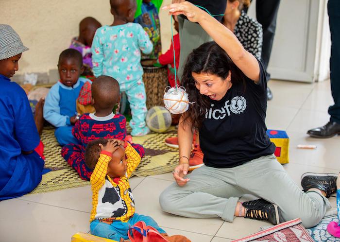 Casey Rotter, founder and managing director of UNICEF NextGen, plays with children at the UNICEF-supported cross-border early childhood development center in Rubavu, Rwanda in 2020.