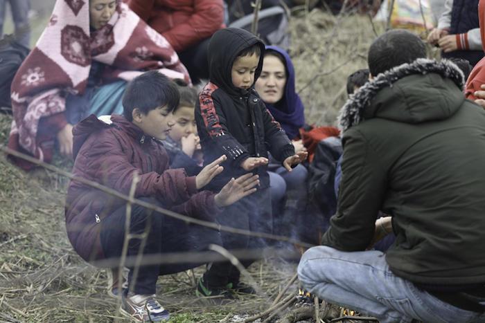 A Syrian family displaced by violence huddles for warmth.