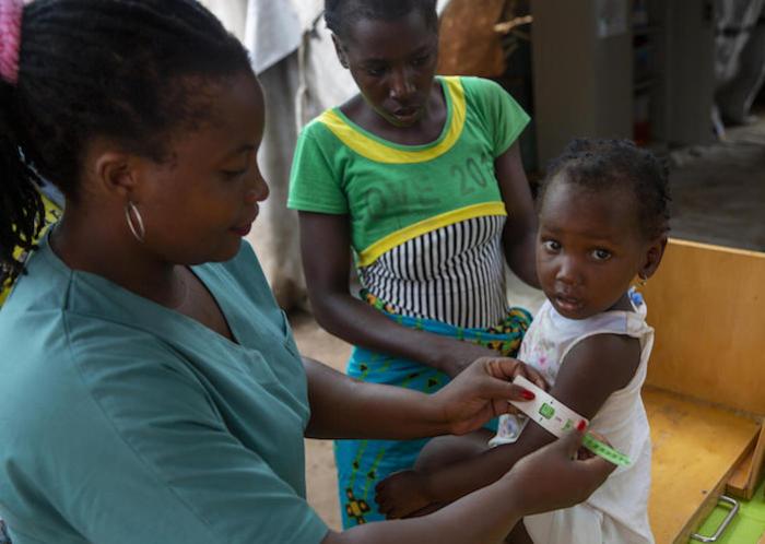 Nurse Madeleina Luis checks children for signs of malnutrition at a UNICEF health center in the Ndjenja resettlement camp, Mozambique, on March 4, 2020.