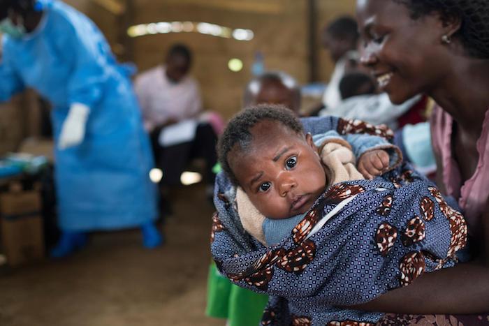 A mother prepares her baby to receive lifesaving vaccines at a UNICEF-supported clinic in the village of Kuka, North Kivu province, DR Congo. 