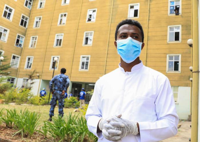 Dr. Minyahel Taye stands outside of the quarantine center at the Civil Service University in Addis Ababa, Ethiopia, as staff register returnees to the country. 