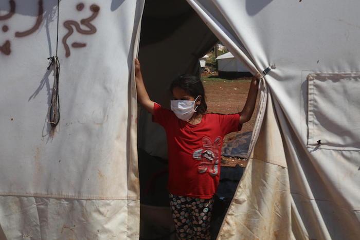 On April 19, 2020, UNICEF volunteers share messaging around staying safe and healthy during the time of the COVID-19 outbreak, in a tent camp for displaced Syrians near the town of Kafr Yahmoul, north of Idlib, Syrian Arab Republic. 