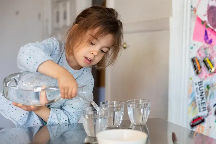 On 19 April 2020, Margot, 4, pours water for her and her parents to have with lunch, at home in New York City, United States of America. Along with more than 1 million other children and youth, Margot has been staying at home with her family since mid-Mar