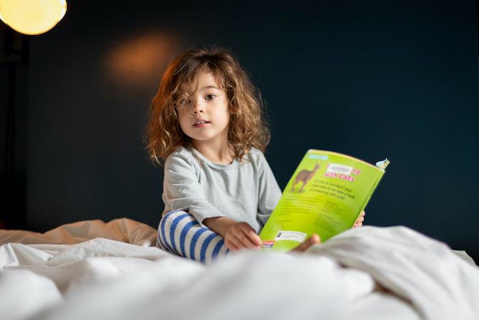 Margot, 4, reads a book at home in New York City, on a weekday she would normally be at daycare.
