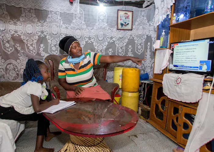 On May 7, 2020 in the Mathare informal settlement in Nairobi, Kenya, Precious (left), 9, is home-schooled by her mother, Mary, while local schools are closed. The two spend most mornings watching lessons.