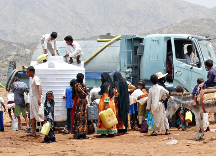 People collect water from one of 20 UNICEF-supplied water tanks in a displacement camp,in Yemen in 2009. 