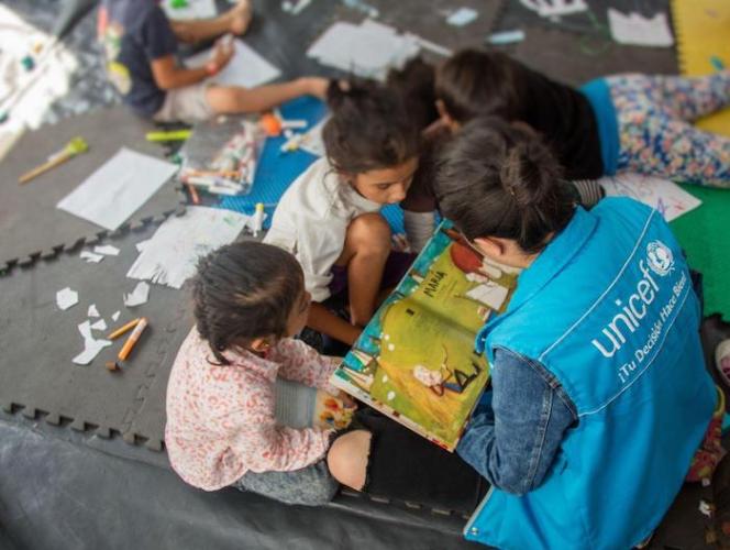 UNICEF's strategy for providing mental health and psychosocial support to migrant children includes creating safe spaces for children to learn and play.
