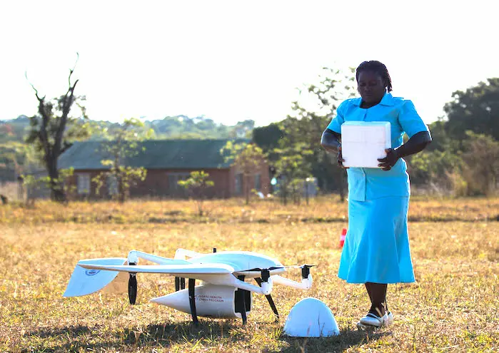 UNICEF-supported community health worker Elizabeth Pemba with the lifesaving drone cargo near the Lifupa health center in Malawi. 
