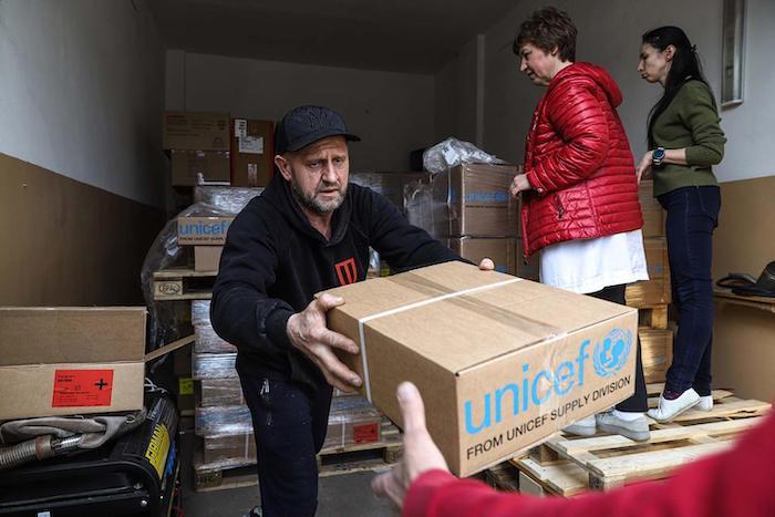 A man helps unload boxes of emergency supplies from UNICEF outside Regional Child Hospital in Zaporizhzhia, Ukraine, on March 30, 2022.