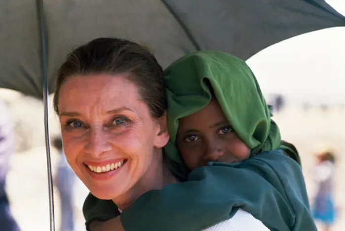 UNICEF Goodwill Ambassador Audrey Hepburn shares her umbrella with an Ethiopian child during one of her many field visits. 