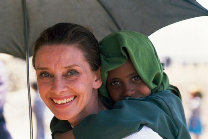 UNICEF Goodwill Ambassador Audrey Hepburn shares her umbrella with an Ethiopian child during one of her many field visits. 