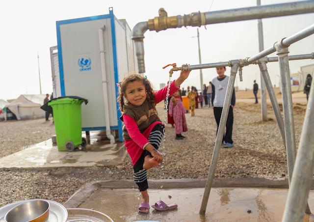 Four-year-old Athra was forced from her home in Mosul by escalating, violent conflict. Now she lives at the Debaga Camp in Erbil Governorate, Iraq, where she can wash at a UNICEF water tap. 