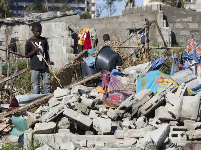 On 24 March 2019 in Mozambique, a boy stands near a destroyed house in an area that was flooded after Cyclone Idai made landfall in Beira.
